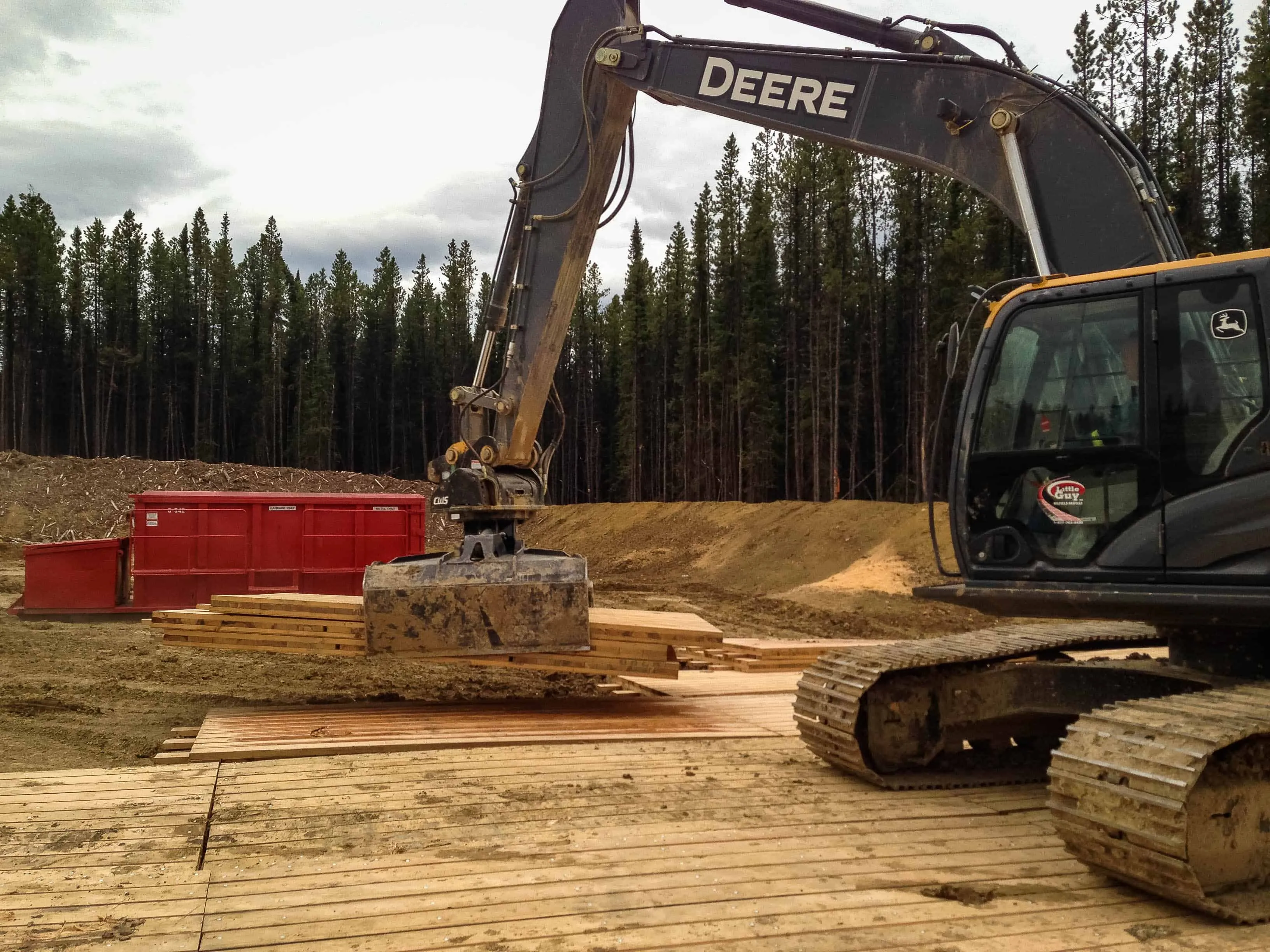 An excavator placing Access Matting mats on a work site